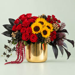 Red roses and yellow sunflowers in a gold vase