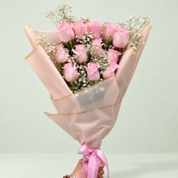 Pink rose bouquet wrapped in blush paper with a ribbon