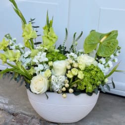 White vase arrangement with green gladiolus, roses, and hydrangeas