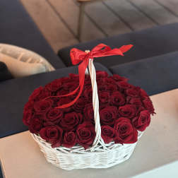 Basket of red roses tied with a red ribbon