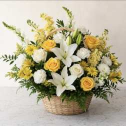 Basket arrangement of white lilies, yellow roses, and white carnations