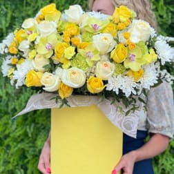 Yellow and white bouquet with roses, orchids, and daisies in a yellow box