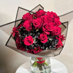 Bouquet of hot pink roses with dark filler flowers in a clear vase