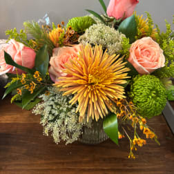 Pink roses and yellow chrysanthemums in a glass vase