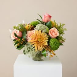 Pink roses and yellow chrysanthemums in a glass vase