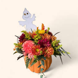 Fall flower arrangement in a pumpkin container with a ghost pick