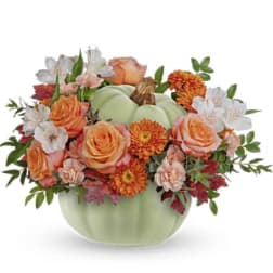 Pumpkin-shaped vase filled with orange and white flowers