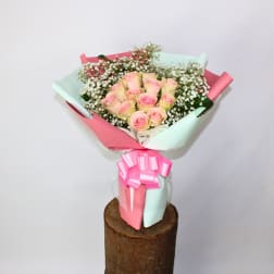 Bouquet of pink roses with baby's breath wrapped in pastel paper
