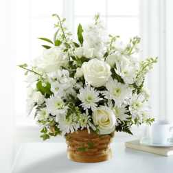 White roses and daisies arranged in a woven basket