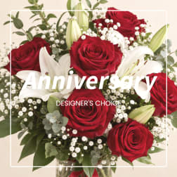 Red roses and white lilies in a glass vase with baby's breath