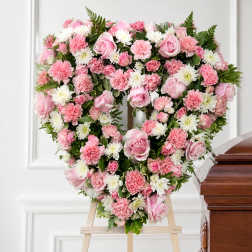 Heart-shaped pink and white floral wreath on an easel