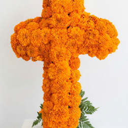 Orange marigold cross arrangement on a white pedestal