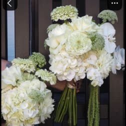 White wedding bouquets with roses, hydrangeas, and orchids