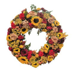 Circular wreath of sunflowers, roses, and red blooms