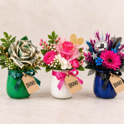 Three decorated flower jars with roses, a pink bouquet, and a disco-themed arrangement