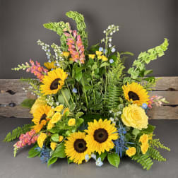 Bright mixed floral arrangement with sunflowers, yellow roses, and pink snapdragons