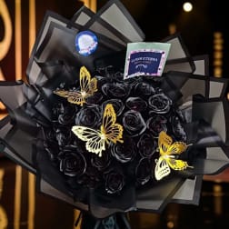 Black rose bouquet with gold butterfly decorations and black wrapping