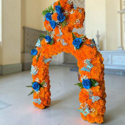 Orange floral arch with blue roses and butterfly accents