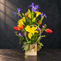Colorful bouquet of tulips and irises in a cream basket with butterfly accents