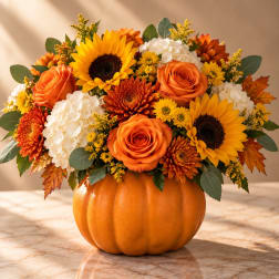 Autumn floral arrangement in a pumpkin-shaped container with sunflowers and orange roses