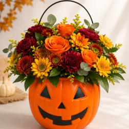 Halloween pumpkin container filled with orange and yellow flowers