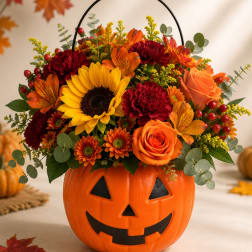 Fall bouquet in a jack-o'-lantern pumpkin container with sunflowers and roses