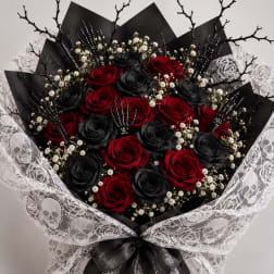 Bouquet of red and black roses wrapped in white lace with a black ribbon.