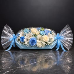 Blue and white flower arrangement wrapped like a candy with ribbon bows