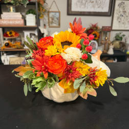 Autumn floral arrangement in a white pumpkin-shaped container