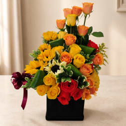 Mixed bouquet of roses and sunflowers in a black box with a burgundy ribbon