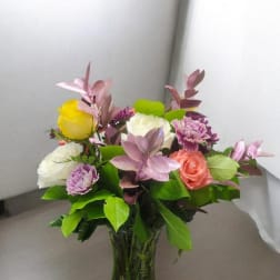 Mixed bouquet of roses and carnations in a clear glass vase