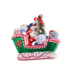 Santa in a decorated sleigh ornament with wrapped gifts and a small tree