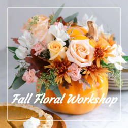 Fall floral arrangement in a pumpkin vase with peach, white, and orange blooms