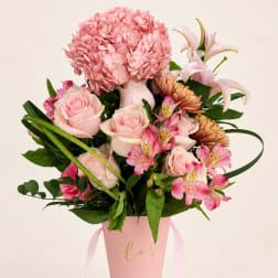 Pink roses and mixed blooms in a pink hatbox with ribbon