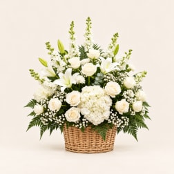 White roses and lilies arranged in a wicker basket
