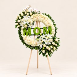 Floral wreath on an easel with green "MOM" lettering