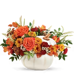 Orange and yellow floral arrangement in a white pumpkin vase