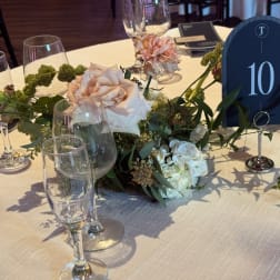 Floral table centerpiece with pale roses and hydrangeas in a low arrangement