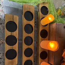 Wooden candle holders with lit orange candles on a decorative table