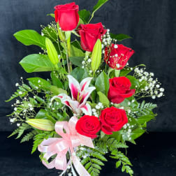 Bouquet of red roses and white lilies with a pink ribbon