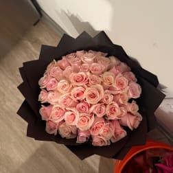 Bouquet of pale pink roses wrapped in black paper