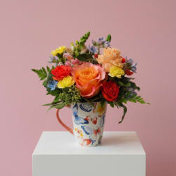 Colorful bouquet of roses and small flowers in a butterfly-patterned mug
