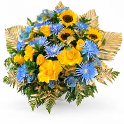 Bouquet of yellow roses and blue flowers in a white vase