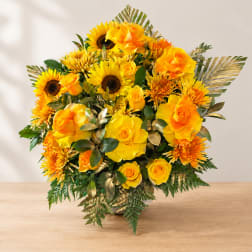 Yellow roses and sunflowers arranged in a vase