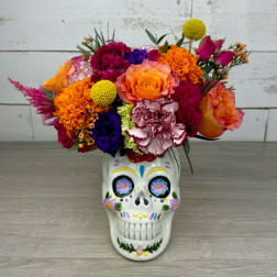 Colorful bouquet in a painted skull vase