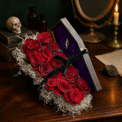Red roses arranged in a coffin-shaped box with a black ribbon.