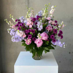 Mixed pink and purple flowers arranged in a clear glass vase
