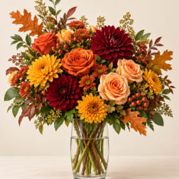 Autumn bouquet of roses and chrysanthemums in a clear glass vase