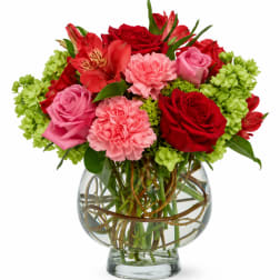 Bouquet of red and pink flowers in a clear glass vase