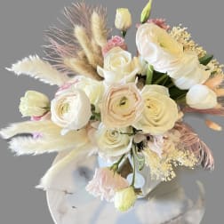 Cream and blush bouquet with roses and ranunculus in a vase